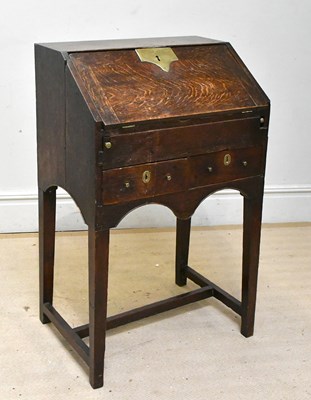 Lot 228 - An 18th century oak bureau on stand, the fall...