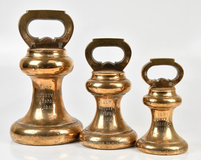 Lot 1324 - Three Victorian brass bell weights, 56lb, 28lb,...