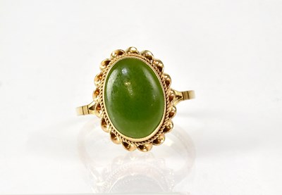 Lot 845 - A 9ct yellow gold ring set with a jade oval...