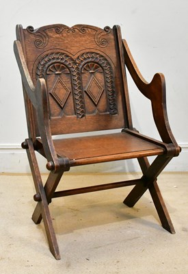 Lot 125 - A carved oak Glastonbury chair.