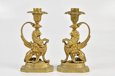 Lot 1337 - A pair of gilt bronze candlesticks modelled as...