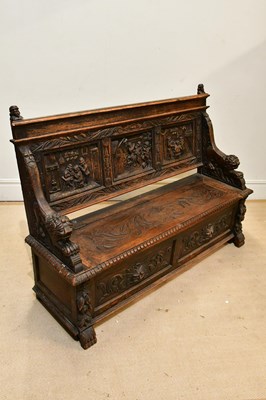 Lot 230 - A Victorian carved oak settle, the panelled...