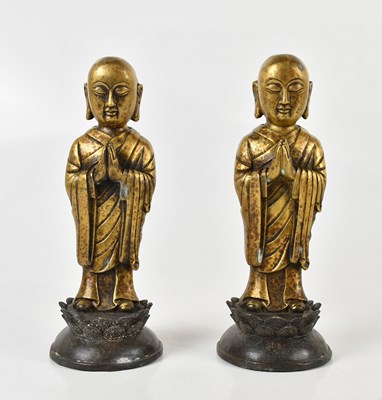 Lot 1168 - A pair of bronzed metal standing Buddhas on...